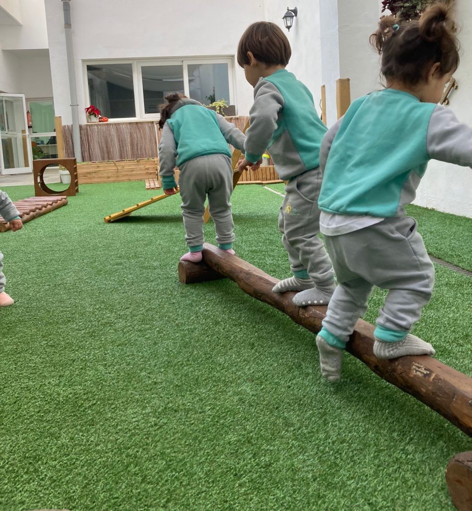 Niños en actividad en barra de equilibrio pikler. Escuela infantil Be YOU